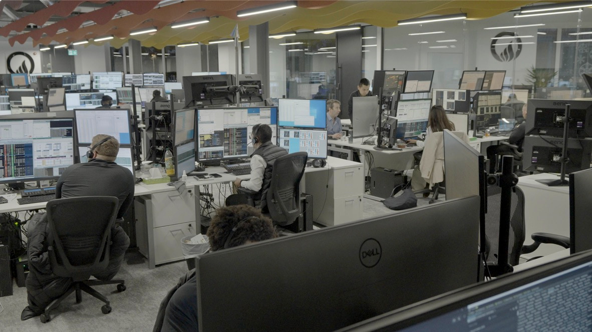 The Onyx trading floor: rows of desks under banks of screens, traders at work across the room, the Onyx mark on the wall